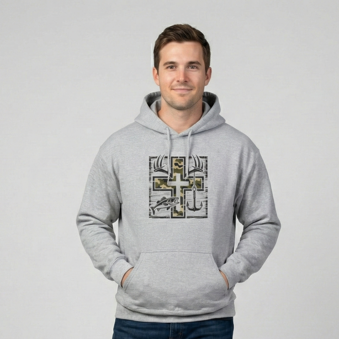 Lifestyle photo of a man wearing a heather gray hoodie with a cross graphic featuring camouflage and fishing elements, including a fish and an anchor, against a neutral background.